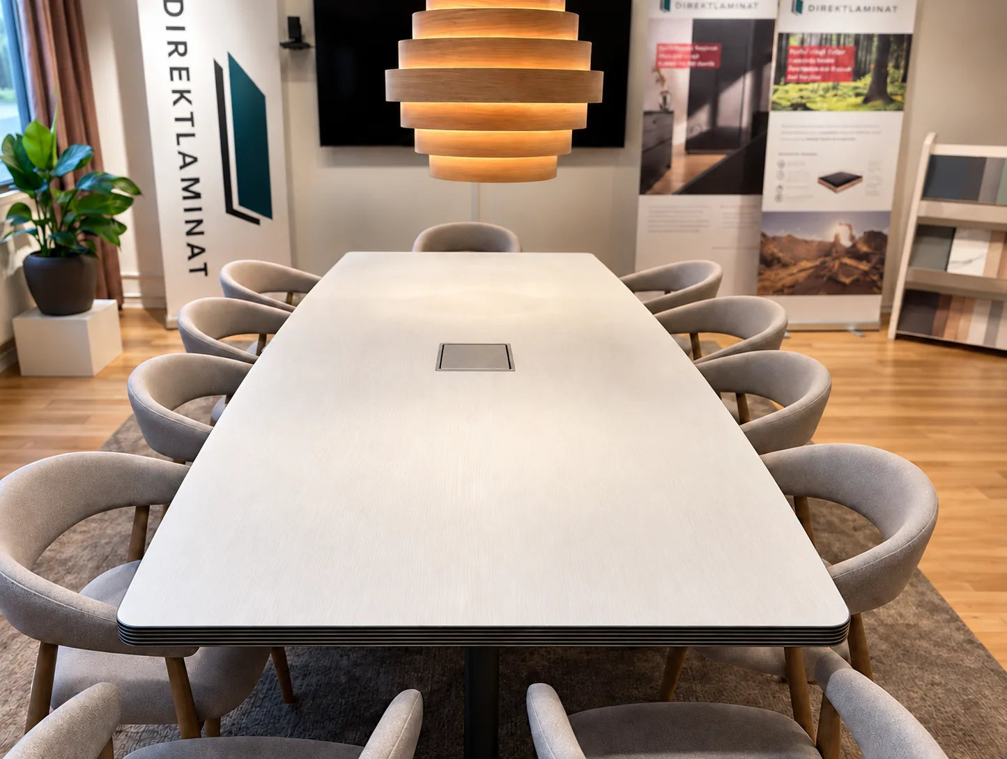 Konferensbord med ljus laminatskiva och stolar runt bordet